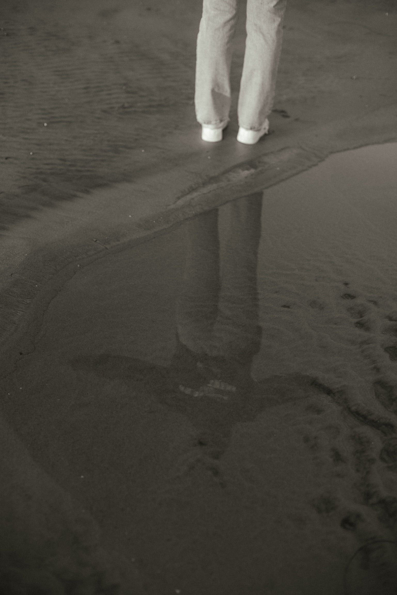 Photo of reflection in the water with a girl wearing a hoodie